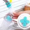 A hand is holding a faucet extender that is spraying water into a sink. Produktbild-Vorschau