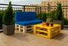 A balcony setting with a pallet sofa and coffee table, decorated with plants and drinks. Produktbild-Vorschau