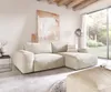 A modern living room with a large sectional sofa, artwork, and a large window overlooking a garden. Produktbild-Vorschau