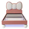 A pink upholstered bed with a bow-shaped headboard and white spherical legs, shown from the front. Anteprima dell’immagine prodotto