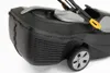 Close-up view of a black lawnmower's grass catcher and wheel. Produktbild-Vorschau