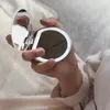 A hand holding a compact mirror with LED lights. Produktbild-Vorschau