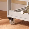 A close-up view of the bottom corner of a gray kitchen cart, showing a clear caster wheel with a black brake mechanism. Voir les images du produit