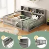 A child's bed with a built-in bookshelf and protective railings, decorated with stuffed animals and pillows. Produktbild-Vorschau