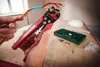Hands using a crimping tool on wires, with a box of connectors and zip ties on a wooden surface. Produktbild-Vorschau