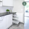 A modern kitchen with white cabinets and a black countertop, featuring a pull-out drawer system with wire baskets. Produktbild-Vorschau