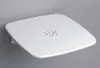 A white shower seat mounted on a gray wall. Produktbild-Vorschau