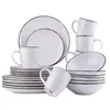 A set of white ceramic dishes with speckled detailing and dark rims, arranged in a studio setting against a white background. Náhled obrázku produktu
