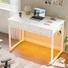 A white desk with a laptop, lamp, and headphones, set up in a room with natural light. Produktbild-Vorschau