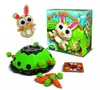 A toy game with a bunny character, a green mound, carrots, and a game box. Produktbild-Vorschau