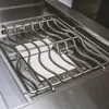 A close-up view of the interior of a stainless steel gas grill, showing the grates and burner cover. Podgląd zdjęcia produktu
