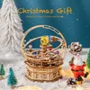 A wooden 3D puzzle model of a solar system or orrery, decorated with colorful crystal spheres, is displayed in a snowy, festive setting with miniature Christmas trees, pine cones, and a Santa Claus figurine. The background is a dark blue with white snowfla Voir les images du produit