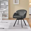 A gray swivel chair is placed on a light gray rug in a room with a white bookshelf and a yellow wall. Produktbild-Vorschau