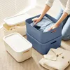 A person is organizing clothes into storage boxes. Produktbild-Vorschau