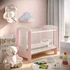 A nursery room with a crib, teddy bear, and toys. Produktbild-Vorschau
