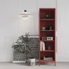 A red metal bookshelf with decorative items on display, placed in a room with white walls and a patterned artwork. Voir les images du produit