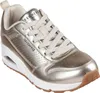 A single gold Skechers sneaker is shown against a white background. Voir les images du produit
