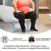 A person is sitting on a shower stool in a bathroom. Produktbild-Vorschau