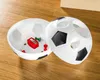 A soccer ball shaped container is open, revealing a pencil sharpener and push pins inside. The container is on a wooden surface. Produktbild-Vorschau