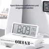 A digital clock with temperature and humidity display sits on top of books. Produktbild-Vorschau