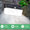 A solar-powered outdoor light mounted on a stone wall, with water droplets on the lens and rain effects. The bottom of the image features icons and text highlighting product features. Produktbild-Vorschau