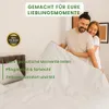 A couple is in bed, holding up a white duvet. Produktbild-Vorschau
