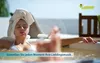 A woman relaxing in a hot tub with a towel on her head, with a small white device floating nearby. Voir les images du produit