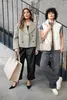 Two women are posing on stairs, one holding a large tote bag and the other a small crossbody bag. Produktbild-Vorschau