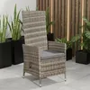 A polyrattan garden chair with a grey cushion is shown in an outdoor setting with plants and a wooden fence in the background. Produktbild-Vorschau