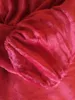 A close-up of a red plush fabric, likely a blanket or bedding. Produktbild-Vorschau