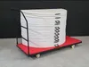 A stack of round folding tables on a red dolly cart against a black background. Produktbild-Vorschau