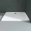 A white rectangular shower tray with a drain in the center, set against a dark gray tiled wall and a light gray floor. Produktbild-Vorschau
