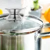 A close-up shot of a steaming pot with a glass lid and a silver handle. Voir les images du produit