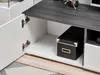 Close-up view of an open cabinet door of a modern entertainment center with a black storage box inside. Produktbild-Vorschau