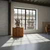 A modern loft-style interior with a wooden pedestal holding a sculpture, illuminated by sunlight streaming through a large window. Náhled obrázku produktu