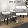 A gray upholstered bench with black legs, placed against a light gray wall. A book is open on the bench, and a pair of black and white sneakers are on the floor underneath. Text overlays highlight product features. Produktbild-Vorschau
