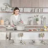 A woman is cooking in a modern kitchen with various appliances and cookware. Produktbild-Vorschau