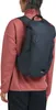 A person wearing a pink sweater and dark pants, with a dark blue backpack on their back. Produktbild-Vorschau