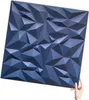 A hand holding a dark blue 3D wall panel. Podgląd zdjęcia produktu