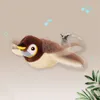 Braun-beiges Plüschvogelspielzeug mit gelbem Schnabel und weißen Augen, im Flug mit Bewegungsunschärfe dargestellt Náhľad obrázku produktu