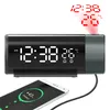 A digital alarm clock with a projected display and a smartphone charging wirelessly. Podgląd zdjęcia produktu