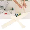 A person's hands are shown working on a sewing project, with various crafting tools and materials laid out on a white table. Produktbild-Vorschau