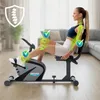 A woman is using a recumbent exercise bike in a living room setting, with graphics highlighting joint support. Produktbild-Vorschau
