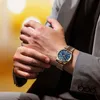 A man in a suit adjusting his watch. Podgląd zdjęcia produktu