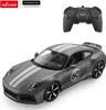 A remote-controlled Porsche 911 toy car and its controller are displayed against a white background. Voir les images du produit