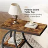 A close-up of a rustic-style side table with a lamp, books, and a cup of coffee on it. Produktbild-Vorschau