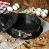 A baking pan with a lid, eggs, hazelnuts, and spoons on a wooden table. Anteprima dell’immagine prodotto