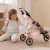 A young girl is playing with a doll stroller in a room. Náhľad obrázku produktu