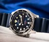 A close-up shot of a Citizen Promaster dive watch with a blue dial and a black rubber strap, set against a blurred blue background and a textured surface. Anteprima dell’immagine prodotto