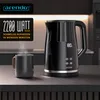 A black electric kettle and a mug on a kitchen counter, with steaming water in the mug. Produktbild-Vorschau
